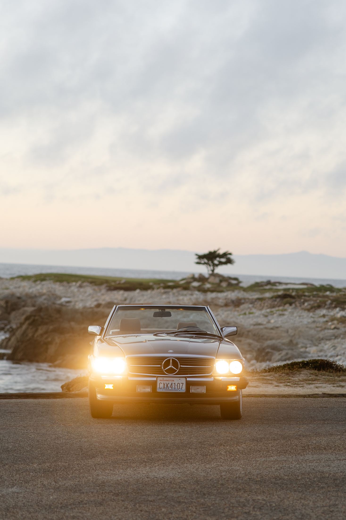 1988 Mercedes-Benz 560 at dusk with headlights on